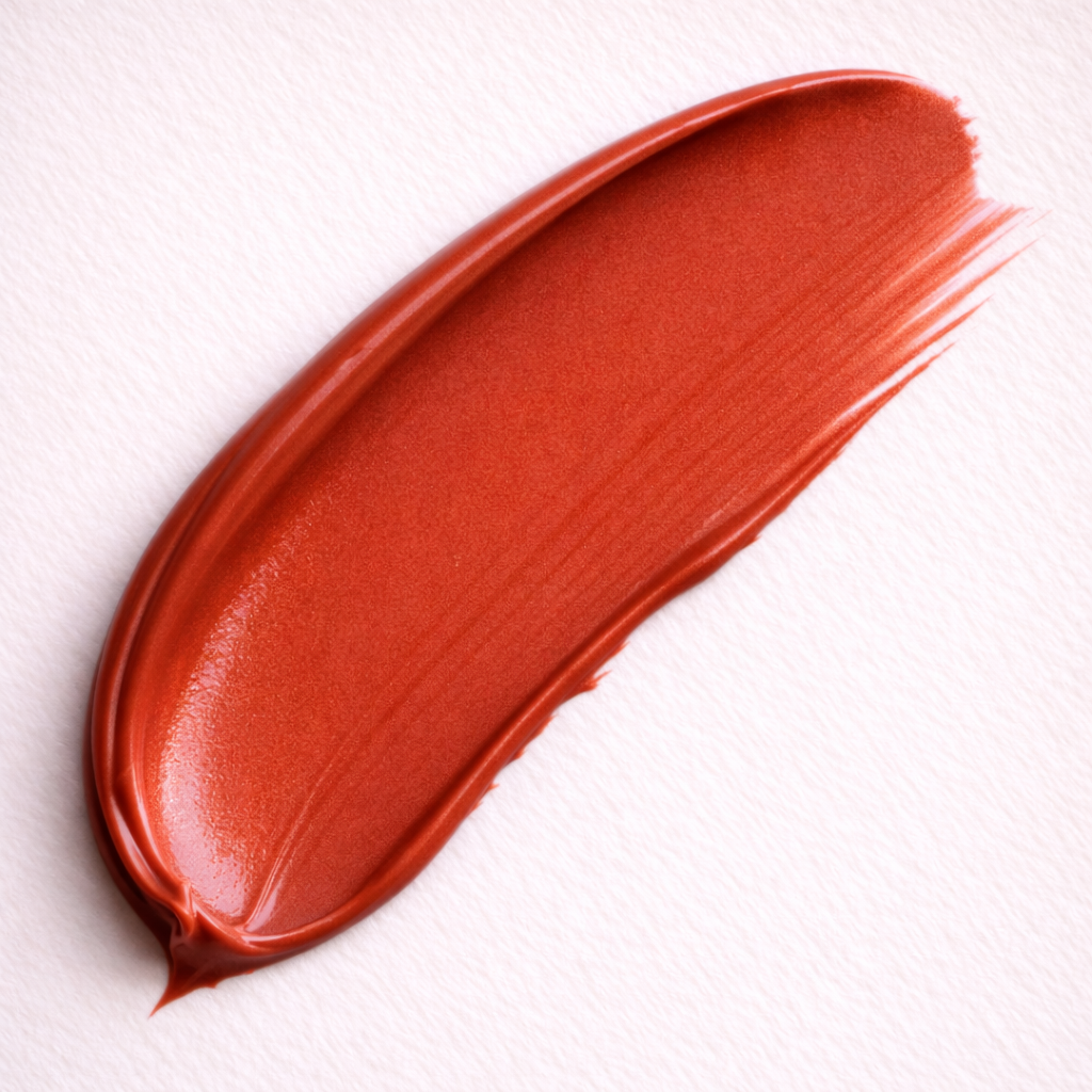 Impulsive coral red cream lipstick smear swatch by Tovielle Beauty vibrant satin finish luxury lipstick texture