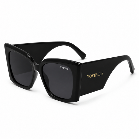 Tovielle Riviera Noir luxury sunglasses featuring an oversized black frame, dark tinted lenses, and signature gold logo detailing on a clean studio background.