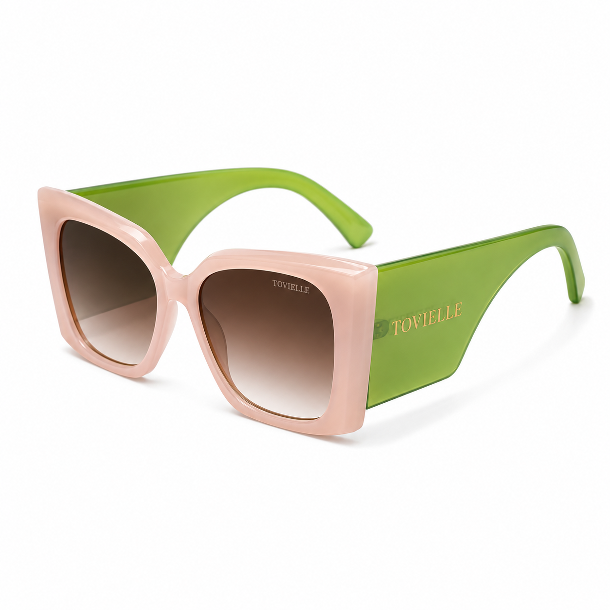 Tovielle Riviera Bloom luxury sunglasses featuring a blush pink oversized frame, translucent green temples, gradient tinted lenses, and signature gold logo detailing on a clean studio background.