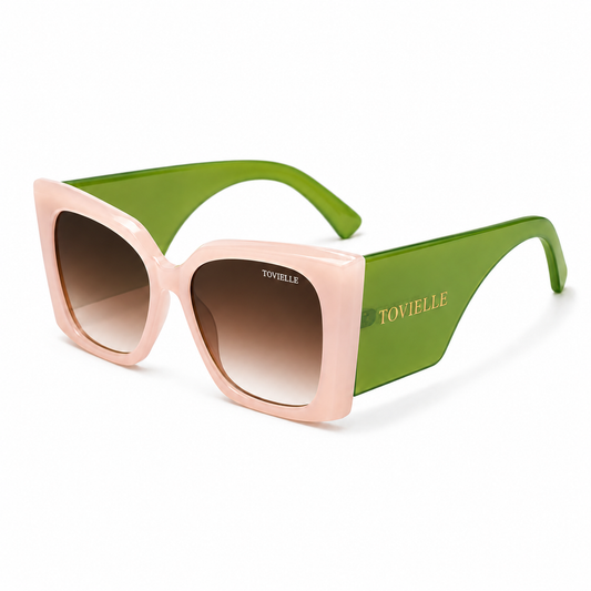 Tovielle Riviera Bloom luxury sunglasses featuring a blush pink oversized frame, translucent green temples, gradient tinted lenses, and signature gold logo detailing on a clean studio background.